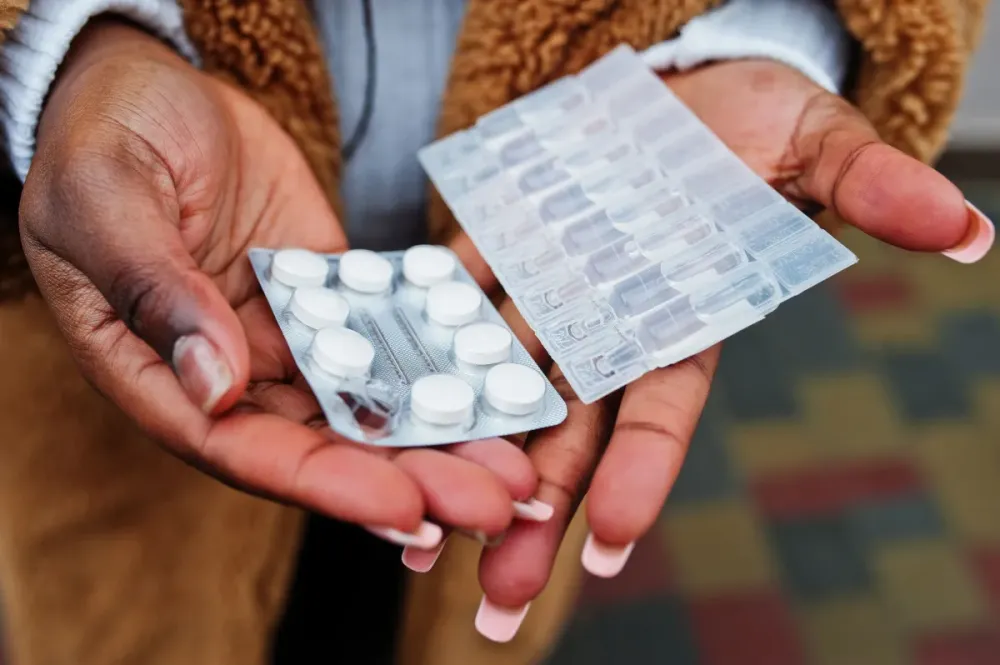Hands of african american woman show pills. • Magnific